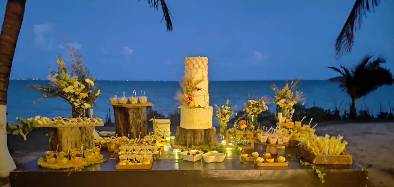 Mesa de postres amarilla frente al mar